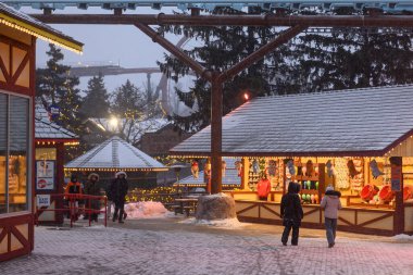 Toronto, ON, Kanada - 31 Aralık 2025: Kanada 'nın Harikalar Diyarı' na kar yağarken insanlar kış festivalinin keyfini çıkarıyorlar, bayram tezgahlarının ve Noel ışıklarının önünden geçiyorlar