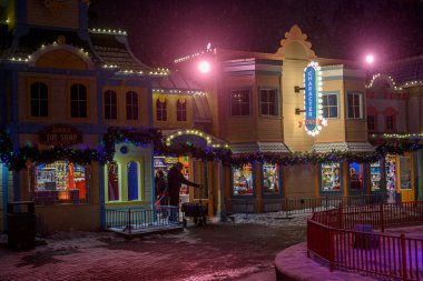 Toronto, ON, Kanada - 31 Aralık 2025: Bir kış festivali sırasında Karakter Evi ve Noel Baba 'nın Oyuncak Dükkanı da dahil olmak üzere ışıklı binaları olan festival caddesi