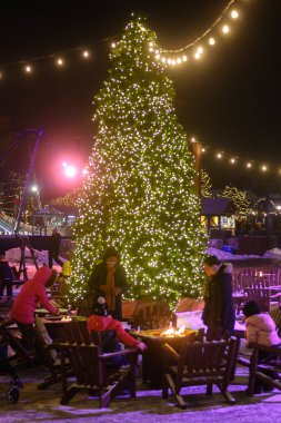 Toronto, ON, Kanada - 31 Aralık 2025: İnsanlar sıcak bir ateş çukurunun etrafında neşeli bir kış gecesinin keyfini çıkarıyorlar.