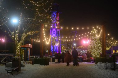 Toronto, ON, Kanada - 31 Aralık 2025 Kış Harikalar Diyarı Festivali 'nin tadını çıkaran insanlar festival ışıkları, aydınlatma kulesi ve geceleri büyük bir Noel ağacı