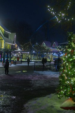 Toronto, ON, Kanada - 31 Aralık 2025: İnsanlar kış festivalinde gece boyunca bina ve ağaçları aydınlatan bayram ışıkları ve dekorasyonlarının keyfini çıkarıyorlar