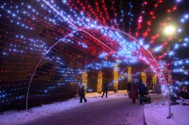 Toronto, ON, Kanada - 31 Aralık 2025: İnsanlar Kanada 'nın Harikalar Diyarı eğlence parkı WinterFest' te renkli yaylı bir tünel boyunca yürüyorlar