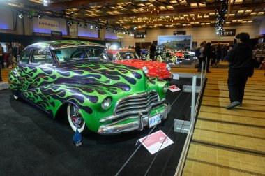 Toronto, ON, Kanada - 13 Şubat 2026: Kanada Uluslararası Otomobil Fuarı 'nda sergilenen yeşil ve mor alev boyalı özel otomobil ziyaretçileri cezbediyor
