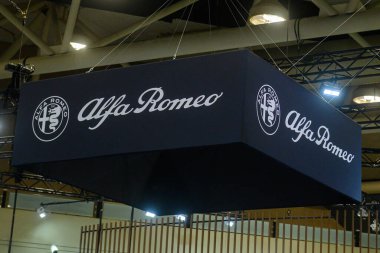 Toronto, ON, Kanada - 13 Şubat 2026: Alfa Romeo bayrağı ve logosu bir Toronto otomobil fuarı, pazarlama ve lüks cazibe için premium otomotiv vitrininde sergilendi