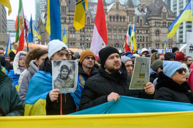 Toronto, ON, Kanada - 22 Şubat 2026: Bir miting için toplanan Ukraynalılar, dayanışma gösteren bayraklar ve pankartlar taşıyarak Nathan Phillips Meydanı 'nda barış çağrısında bulundu