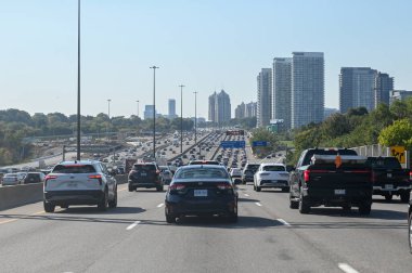 Toronto, ON, Kanada - 10 Ağustos 2025: Açık bir günde şehrin ufuk çizgisi yakınlarındaki kalabalık bir otoyolda arabalar yavaş hareket ediyor.
