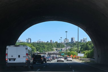 Toronto, ON, Kanada - 10 Ağustos 2025: Otoyolda yoğun trafik akışı gündüz vakti karanlık tünel girişinden görülebiliyor.
