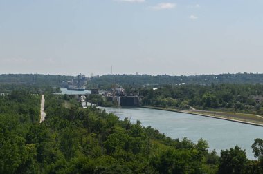 Thorold, ON, Kanada - 10 Ağustos 2023: Bu manzara, parlak, güneşli bir günde Welland Kanalı 'nın yeşil bir arazide aktığını gösteriyor.