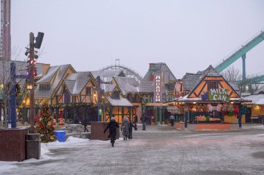 Toronto, ON, Kanada - 31 Aralık 2025: Festival ışıkları ve karla süslenmiş tema parkı binaları, kış tatili ruhunu ve açık hava eğlencesini yakalıyor