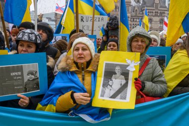 Toronto, ON, Kanada 22 Şubat 2026: Ukrayna halkı istila yıldönümü münasebetiyle düzenlenen mitingde ellerinde kurbanların ve ulusal bayrakların portrelerini tutarak savaşa karşı gösteri yapıyor.