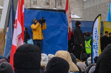 Toronto, ON, Kanada - 22 Şubat 2026: Rusya 'nın Ukrayna ve Ukrayna bayrakları ile tam ölçekli işgalinin dördüncü yıldönümü münasebetiyle düzenlenen mitinglere katılan insanlar