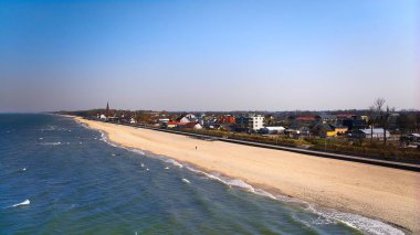 Sarbinowo 'nun sahil ve kıyı şeridini, yumuşak dalgalar ve sakin ufuklarla gösteren insansız hava aracı görüntüsü..