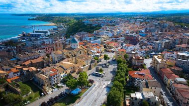 Ortona 'nın klasik çatılar, açık gökyüzü ve yukarıda sürüklenen küçük beyaz bulutlar tarafından çerçevelenen miras bölgesinin yükseltilmiş görüntüsü.