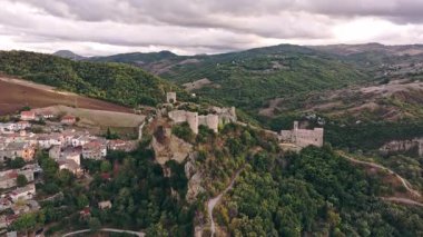 Roccascalegna 'nın uçurum kenarındaki şatosu, geleneksel kasaba ve yemyeşil tarlaları Abruzzo arazisi boyunca uzanıyor..