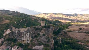 Roccascalegna kalesinin yeşil vadileri ve kırsal arazileri süpüren kayalık bir tepedeki insansız hava aracı görüntüleri..