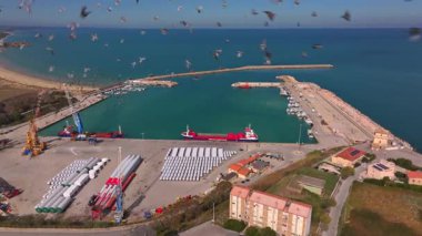 Vasto limanının hava görüntüleri liman altyapısını, kargo gemilerini, küçük tekneleri ve Adriyatik Denizi 'ni, kıyı şeridini, tarlaları ve liman bölgesini çevreleyen binaları gösteriyor..