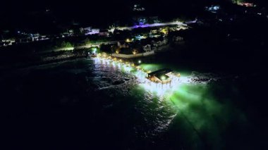 Günbatımından sonra parlayan geleneksel trabocco, sakin dalgalar ve kayalık kıyı şeridiyle çevrili..