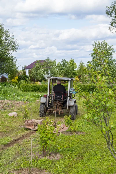 Старый трактор работает в поле — стоковое фото