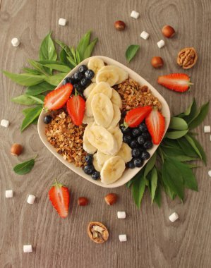 Granola muz, çilek ve böğürtlen sağlıklı bir kahvaltı için 