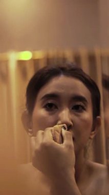 Büyüleyici bir dönüşüm, titizlikle makyaj yapan genç bir kadın zarif ve özgüvenli bir şekilde kendini geliştirir.