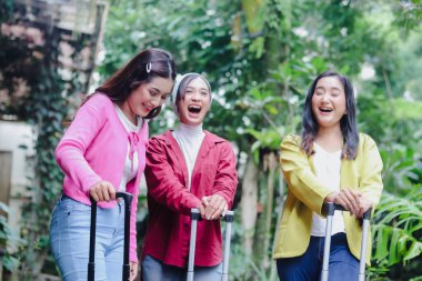 Üç hayat dolu genç kadın, yolculuklarına hazır olarak kahkahalar ve heyecanı paylaşıyorlar. Doğayla çevrelenmiş olan sevinçleri, beklenen tatil deneyimlerine başlarken bulaşıcıdır..