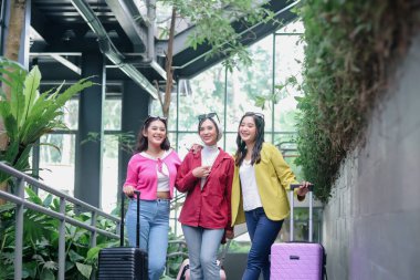 Üç şık kadın birlikte bir yolculuğa çıkarken, bavullarını coşkuyla çekerek mutluluk saçıyor. Gülüşleri önlerindeki tatilin heyecanını yansıtıyor, arkadaşlığı teşvik ediyor..