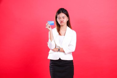 Beyaz ceketli bir kadın mavi bir kart tutuyor, ağzı biraz bozuk, kırmızı arka planda izole edilmiş.