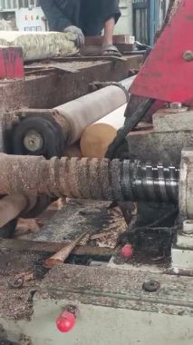 Ağır makinelerle karşılaşırken ham ahşabın dönüşümünü tecrübe edin. Bu ilgi çekici görüntü, tahtanın çekirdek materyallere dönüşümünün endüstriyel işleyişini gösteriyor..