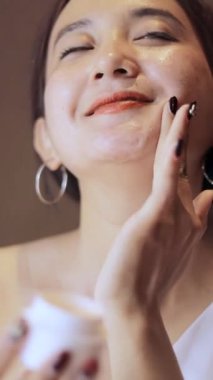 Genç kadınların cilt bakımı rutin hale gelir. Mutlulukla nemlendirici sürerler. Sağlıklı ciltler sergilerler.,