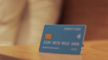 Kredi kartı sabit çekimi, ahşap mobilyaların üzerinde dinlenme, sergilenen finans ve dijital ödeme yöntemleri,