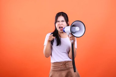 Bir insan beyaz bir megafonu tutarken parmağıyla turuncu bir arka planı işaret eder..