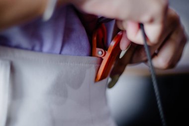 Üzerinde siyah bir kordon bulunan turuncu bir şarjör olan dar ve detaylı bir çekim. Odak noktası klipsin dokusu ve pratik kullanımı..