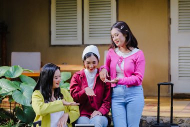 Üç neşeli arkadaş dışarıda toplanıyor, heyecanlı bir şekilde bir sonraki kaçışlarını planlıyorlar. Seyahat fikirlerini paylaşarak ve tablette ilginç bir şey göstererek bavullarını toplamaya hazırlar..