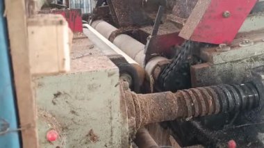 Ahşap işçiliği yapan bir makinenin detaylı bir yakın çekimi. Parçaları ve talaşları döndüren, marangozluk ve marangozluk sektörlerindeki endüstriyel süreçleri yakalayan özellikler.