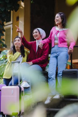 Heyecanla dolup taşan üç genç kadın yolculuklarını sabırsızlıkla bekliyor. Bavullarla çevrili yüzleri, unutulmaz bir seyahat deneyimi için hazırlanırken heyecan saçıyor..