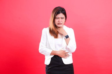 Beyaz ceketli bir kadın boğazını tutuyor. Kırmızı arka planda izole edilmiş rahatsızlık ya da hastalık belirtileri gösteriyor.