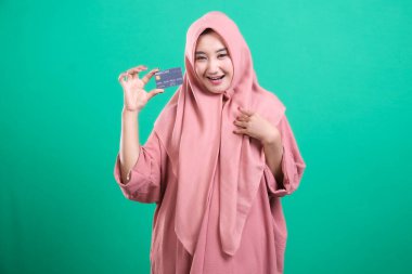 Yeşil arka planda izole edilmiş, tesettürlü, tesettürlü, tesettürlü, tesettürlü, tesettürlü neşeli Müslüman kadın. Modern, mütevazı ve güvenli finansal hizmetleri teşvik etmek..