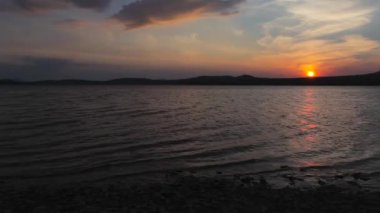 Bir dağ gölünün kıyısında gün batımı