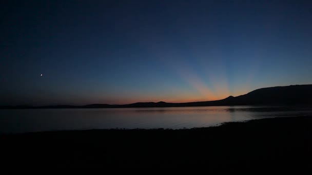 Puesta de sol en la orilla de un lago de montaña — Vídeo de stock