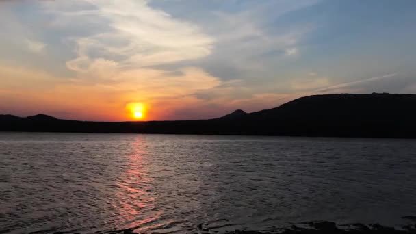 Pôr do sol na margem de um lago de montanha — Vídeo de Stock