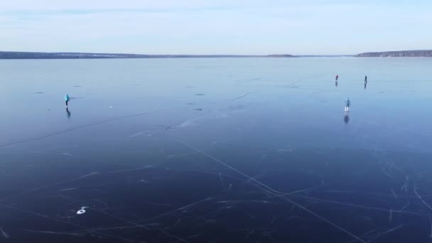 凍った水槽の上で屋外でスケート友達のグループの空中トップビュー クリップ 足の下に深い亀裂を持つ厚い氷で凍結湖でスケート男と女 — ストック動画