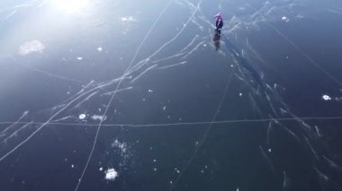 Bir adamın havadan görünüşü kız arkadaşına kışın açık hava deposunda el ele tutuşarak kaymayı öğretir. Şarjör. İnsanlar ve açık hava eğlence konsepti