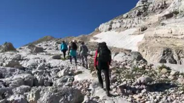 Bir grup turist dağlara seyahat eder. İnsanlar tepeye tırmanır.