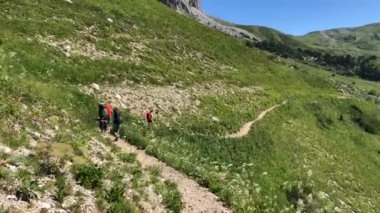 Bir grup turist dağlara seyahat eder. İnsanlar tepeye tırmanır.