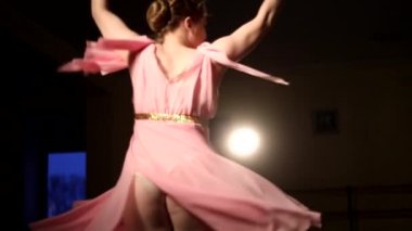 Genç zarif balerin, arka planda ışıkla karanlıkta dans eden klasik balerin unsurları. Karanlıkta genç ve güzel bir balerin. Stüdyoda bale çalışması.