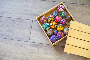 Ahşap bir hediye kutusunda çok renkli parlak örülü toplar.