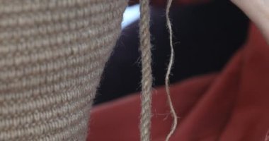 Kadın, çevre dostu malzemelerden örgü örüyor. Ev dekorasyonu için jüt iplik. Ev hobisi kalın duvarlı halat sepetleri örmek. İç mekanda el işi. Örgü jüt ve ip sepetleri..