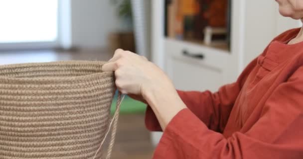 这个女人正在从环境友好材料中偷工减料 黄麻纤维做家居装饰 在家编织厚壁绳篮的嗜好 室内的手工活 针织黄麻和绳篮 — 图库视频影像