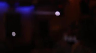 Dans pistindeki neon ışıkları. Bulanık bokeh. İnsanlar dans pistinde zıplıyor ve ellerini sallıyorlar. Eğlence, geçmiş ve parti konsepti