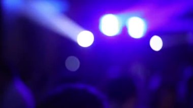 Dans pistindeki neon ışıkları. Bulanık bokeh. İnsanlar dans pistinde zıplıyor ve ellerini sallıyorlar. Eğlence, geçmiş ve parti konsepti